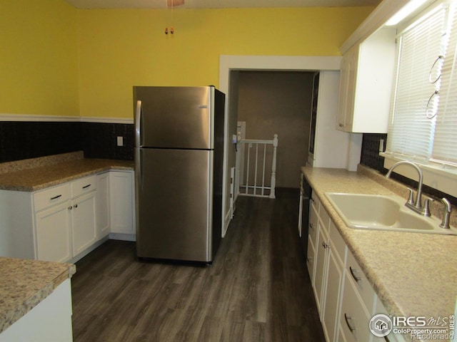 kitchen with stainless steel refrigerator, white cabinetry, sink, and dark hardwood / wood-style floors