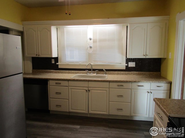 kitchen with backsplash, white refrigerator, sink, dark hardwood / wood-style floors, and white cabinetry