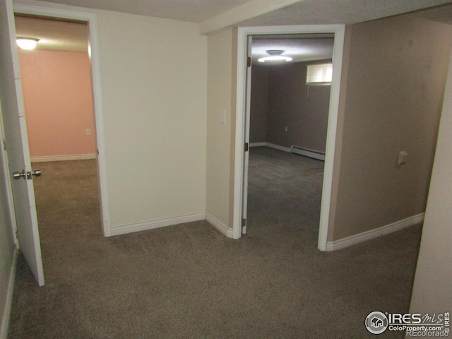 hall with dark colored carpet, a textured ceiling, and a baseboard heating unit