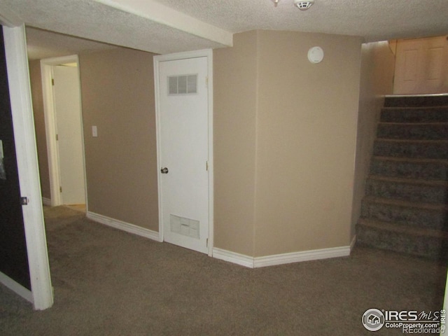 basement with dark colored carpet and a textured ceiling