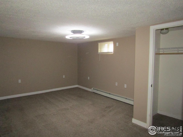 basement featuring a textured ceiling, carpet floors, and baseboard heating