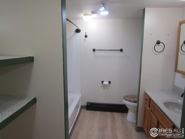 full bathroom with hardwood / wood-style floors, vanity,  shower combination, toilet, and a baseboard radiator