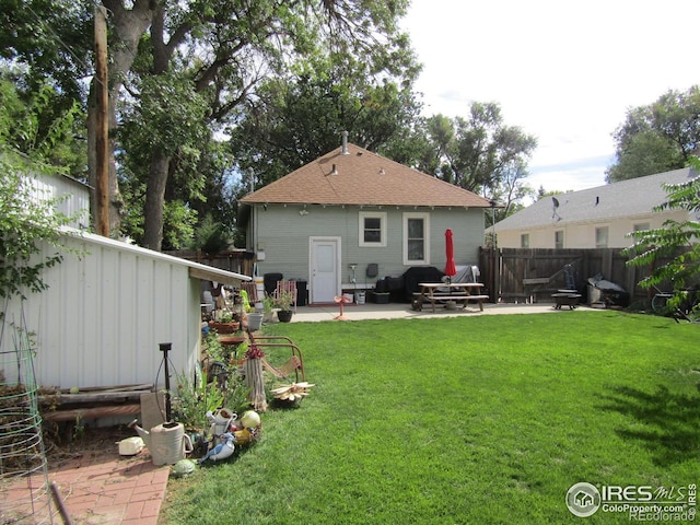 rear view of property featuring a patio area and a yard