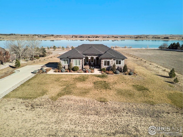 view of front of property with a front lawn and a water view