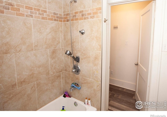 bathroom featuring hardwood / wood-style flooring and tiled shower / bath