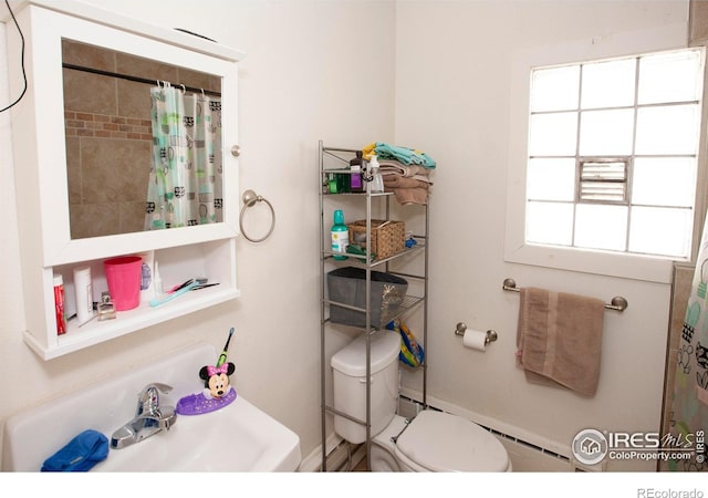 bathroom with a shower with shower curtain, toilet, a wealth of natural light, and sink