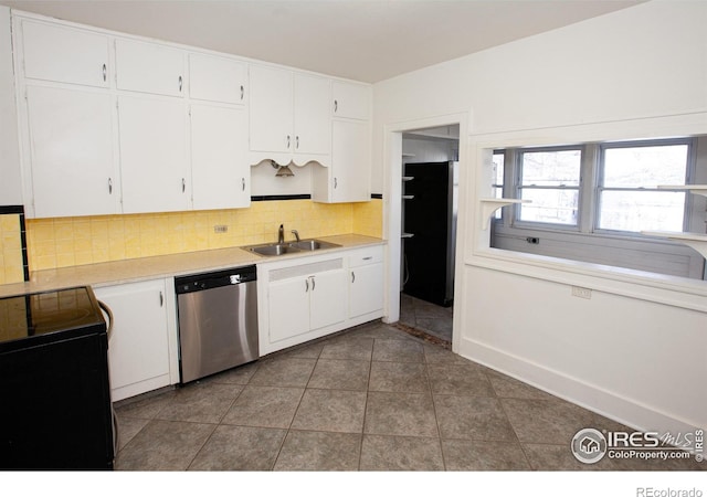 kitchen featuring sink, white cabinets, dark tile patterned flooring, decorative backsplash, and stainless steel dishwasher