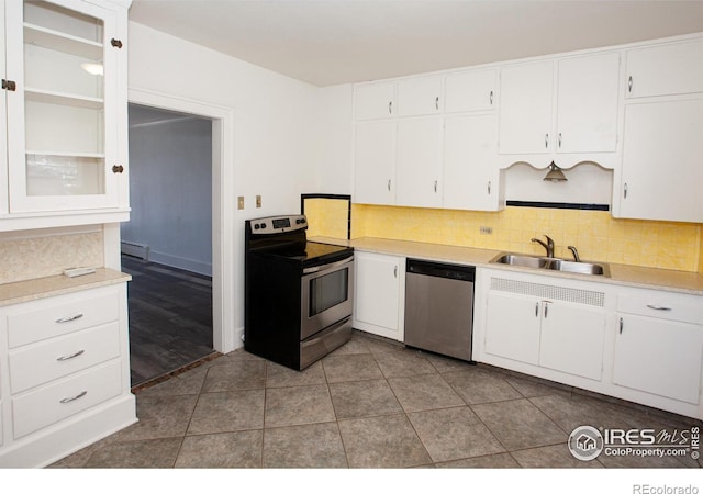 kitchen with sink, tasteful backsplash, white cabinets, stainless steel appliances, and a baseboard heating unit