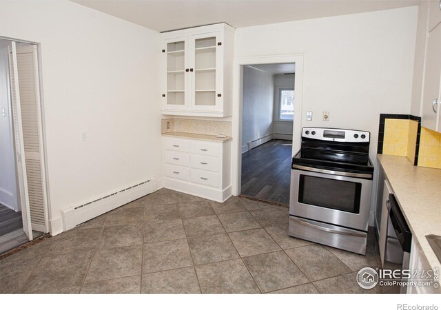 kitchen with stainless steel electric stove, light tile patterned flooring, black dishwasher, white cabinets, and baseboard heating