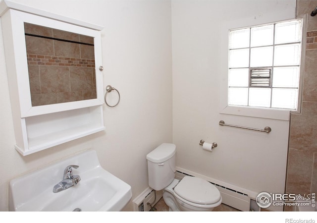 bathroom with sink, toilet, and a baseboard heating unit