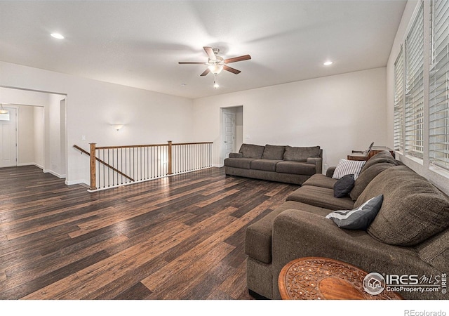 living room with ceiling fan and dark wood-type flooring