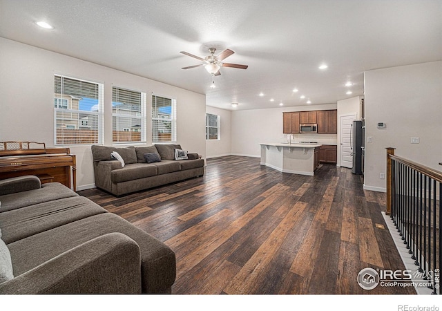 living room featuring a textured ceiling, dark hardwood / wood-style flooring, and ceiling fan