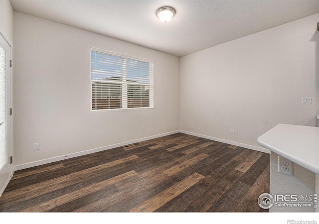 unfurnished room with dark hardwood / wood-style flooring