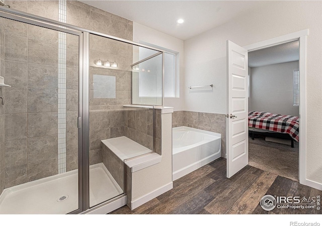 bathroom with hardwood / wood-style flooring and independent shower and bath