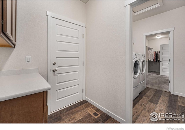 laundry room featuring washing machine and dryer, dark hardwood / wood-style flooring, and cabinets