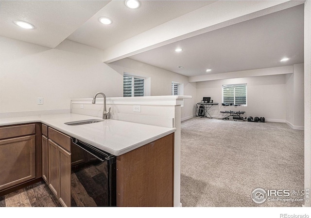 kitchen featuring kitchen peninsula, sink, beverage cooler, and dark colored carpet