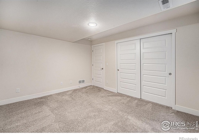 unfurnished bedroom with a closet, carpet floors, and a textured ceiling