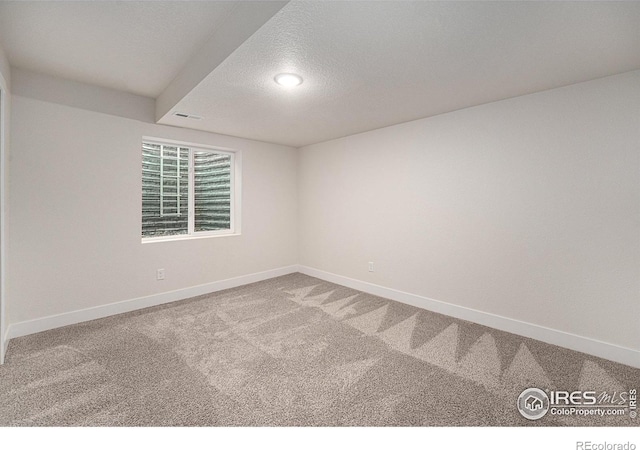 empty room featuring carpet flooring and a textured ceiling