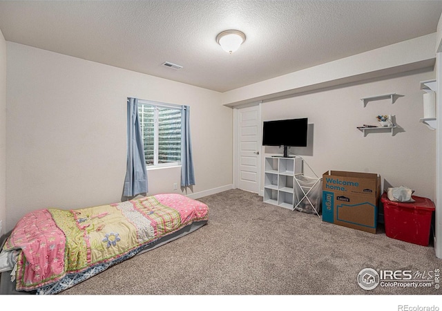 bedroom featuring carpet and a textured ceiling