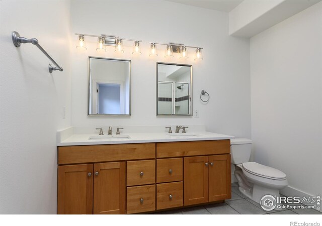 bathroom featuring tile patterned flooring, vanity, walk in shower, and toilet