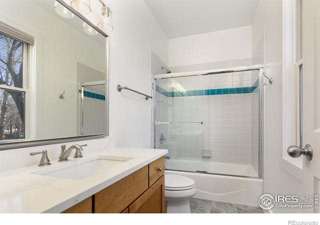 full bathroom featuring bath / shower combo with glass door, vanity, and toilet