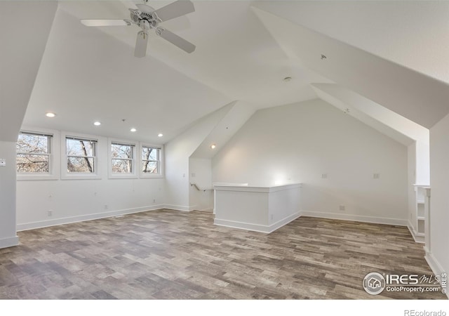 additional living space featuring wood-type flooring, vaulted ceiling, and ceiling fan