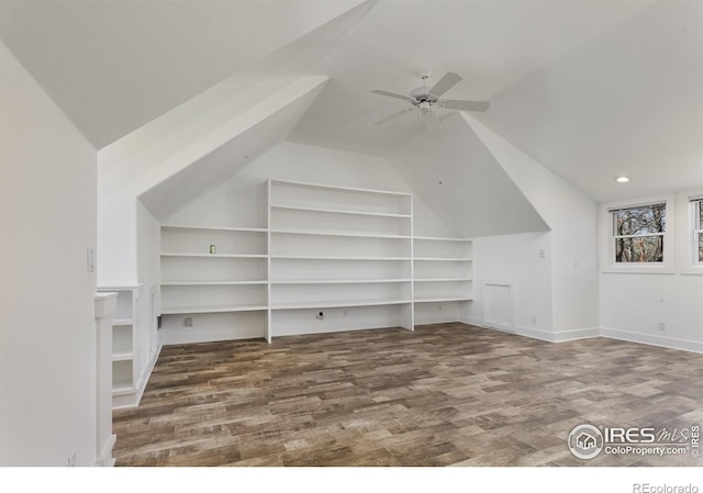 additional living space with vaulted ceiling, hardwood / wood-style floors, ceiling fan, and built in shelves