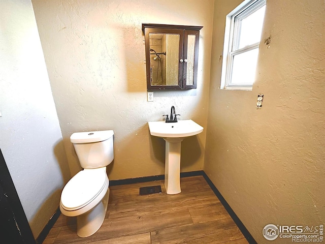 bathroom with hardwood / wood-style floors, toilet, and sink