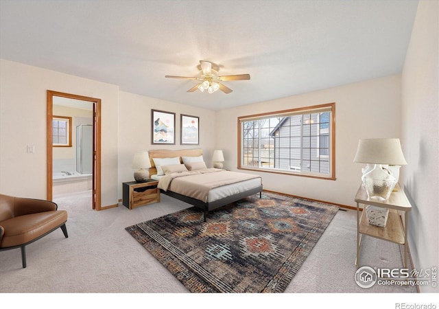 bedroom featuring light colored carpet, ensuite bath, and ceiling fan