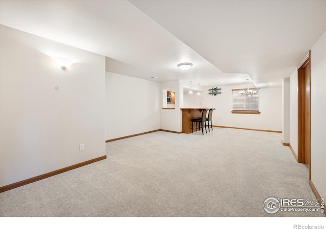 basement with a notable chandelier and light carpet