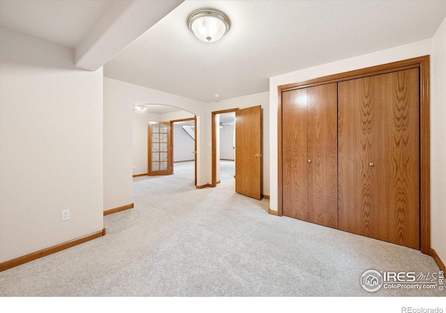 unfurnished bedroom with light carpet and a closet