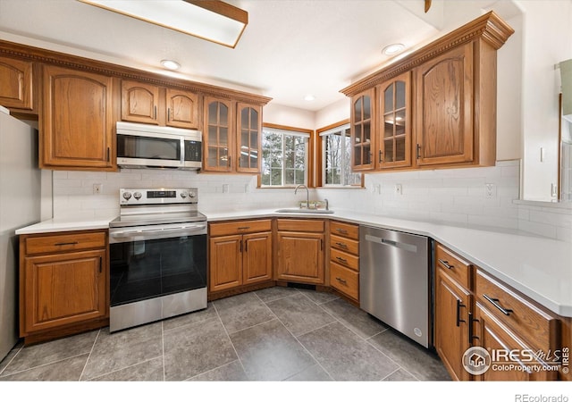 kitchen with decorative backsplash, sink, and stainless steel appliances