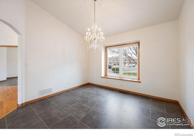 empty room featuring vaulted ceiling and a notable chandelier