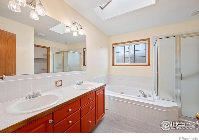 bathroom with vanity, tasteful backsplash, independent shower and bath, and a skylight