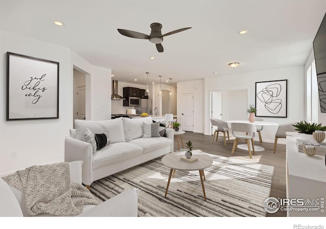 living room with hardwood / wood-style floors, ceiling fan, and sink