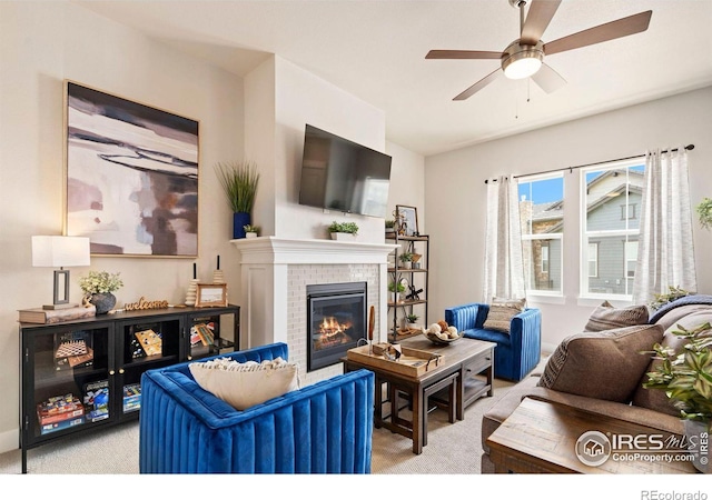 carpeted living room featuring a fireplace and ceiling fan