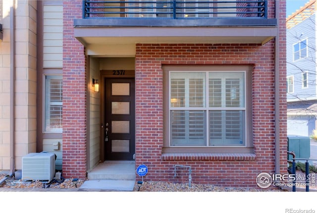 entrance to property featuring cooling unit and a balcony