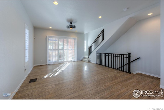 unfurnished living room with ceiling fan and hardwood / wood-style flooring