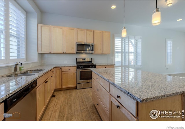 kitchen with a center island, stainless steel appliances, plenty of natural light, and sink