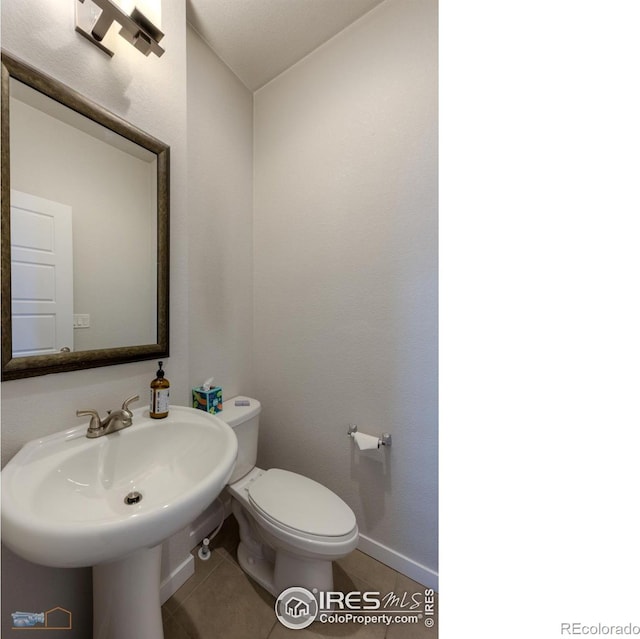 bathroom featuring tile patterned flooring, toilet, and sink