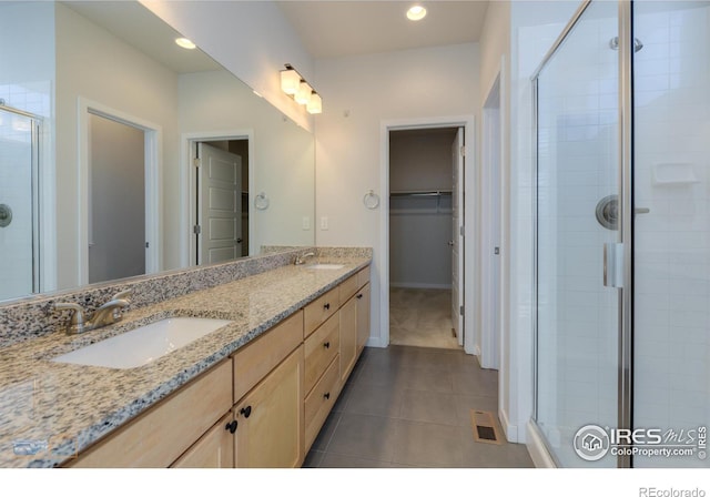 bathroom featuring vanity, tile patterned floors, and a shower with door