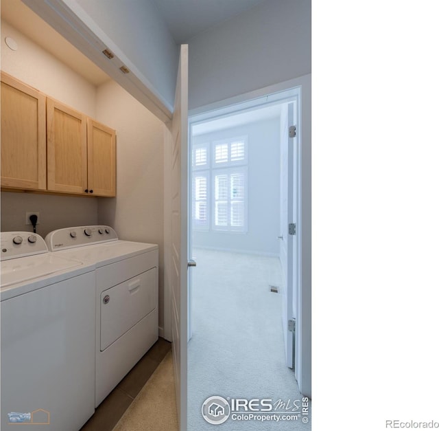 clothes washing area featuring cabinets, separate washer and dryer, and light carpet