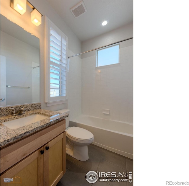 full bathroom featuring tiled shower / bath, tile patterned flooring, vanity, and toilet