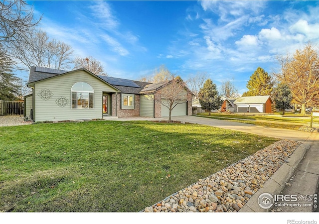 ranch-style house featuring solar panels, a garage, and a front lawn