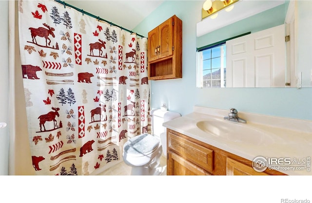 bathroom with vanity, curtained shower, and toilet