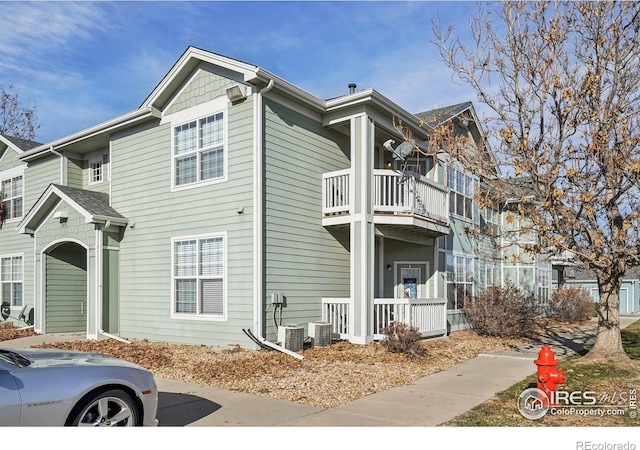 view of front of house featuring a balcony and central AC