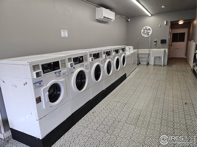 washroom featuring independent washer and dryer and a wall mounted air conditioner