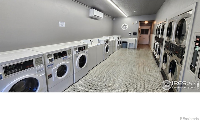 clothes washing area with stacked washer and dryer, a wall unit AC, and washer and clothes dryer