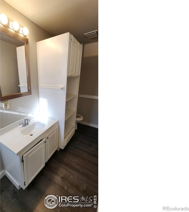 bathroom with vanity, hardwood / wood-style floors, and toilet