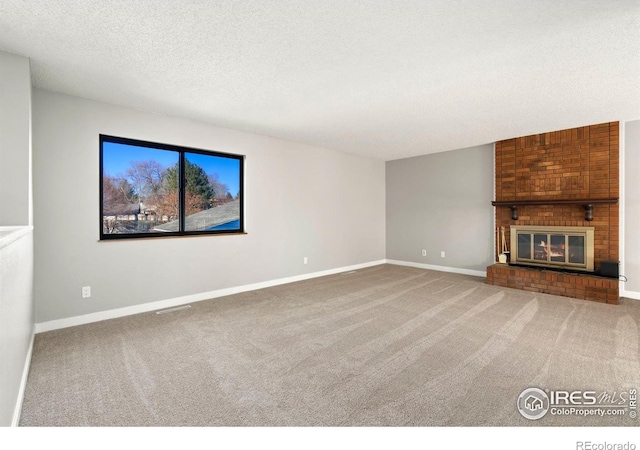 unfurnished living room featuring carpet flooring, a fireplace, and a textured ceiling